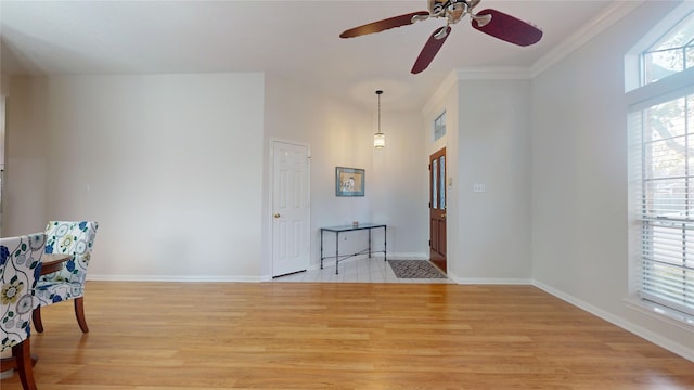 interior space with baseboards, ornamental molding, light wood-style flooring, and a healthy amount of sunlight