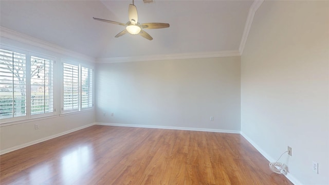 spare room featuring light wood finished floors, baseboards, ceiling fan, ornamental molding, and vaulted ceiling