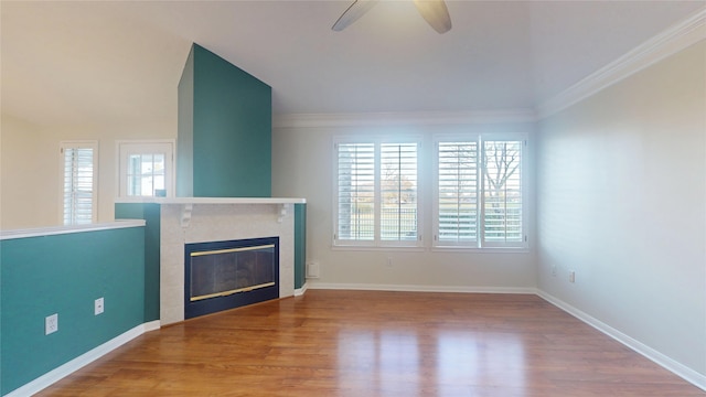 unfurnished living room featuring plenty of natural light, ornamental molding, and wood finished floors