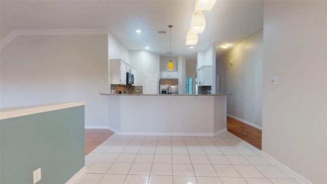 kitchen featuring stainless steel fridge with ice dispenser, a peninsula, stone counters, black microwave, and backsplash