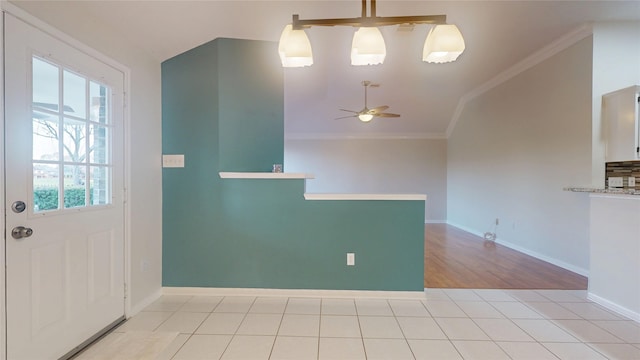 entrance foyer with ceiling fan, lofted ceiling, light tile patterned flooring, baseboards, and crown molding