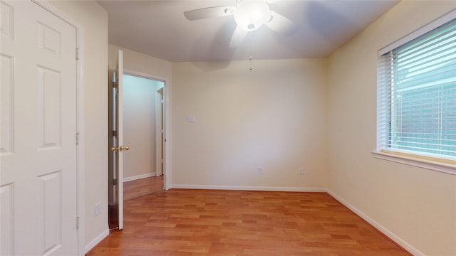 unfurnished room featuring baseboards, ceiling fan, light wood-style floors, and a healthy amount of sunlight