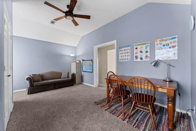 carpeted office space with baseboards, visible vents, vaulted ceiling, and a ceiling fan