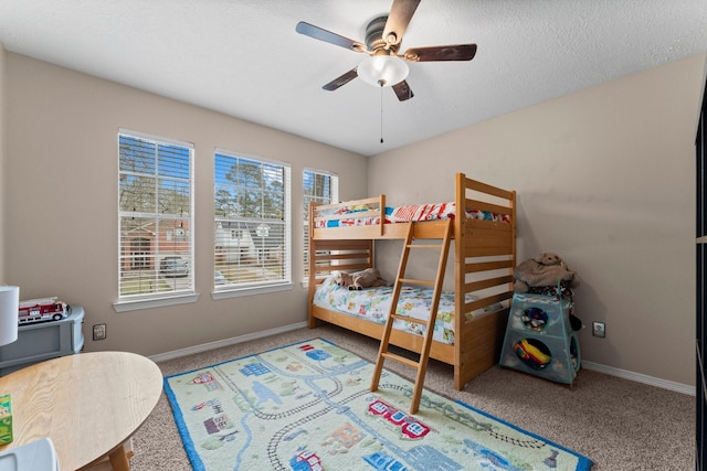 bedroom with a textured ceiling, ceiling fan, carpet, and baseboards