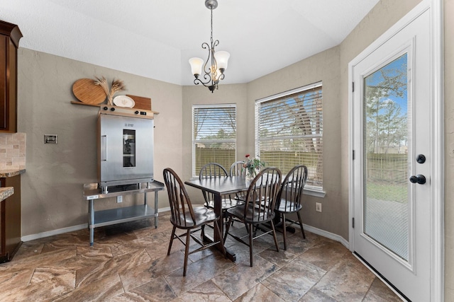 dining space featuring baseboards and an inviting chandelier