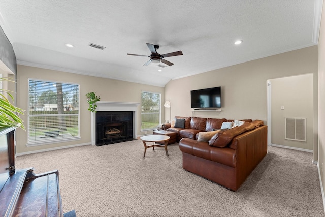 carpeted living area featuring a healthy amount of sunlight, a fireplace, and visible vents