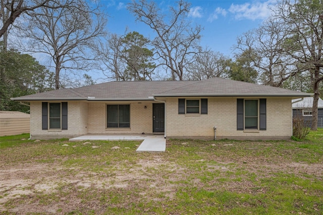 back of property featuring a patio area, a lawn, and brick siding