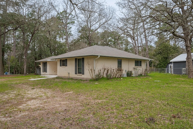 rear view of house with a lawn and brick siding