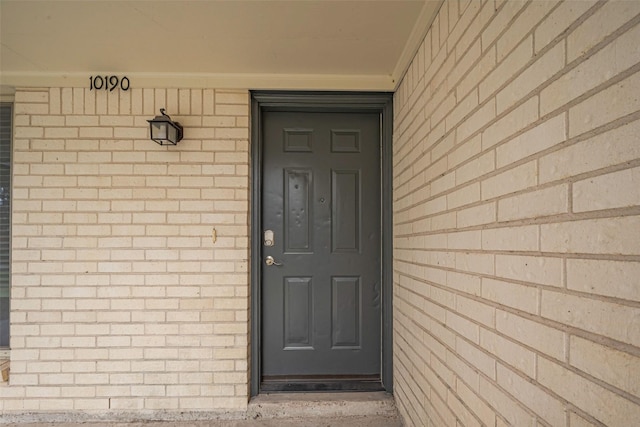 entrance to property featuring brick siding