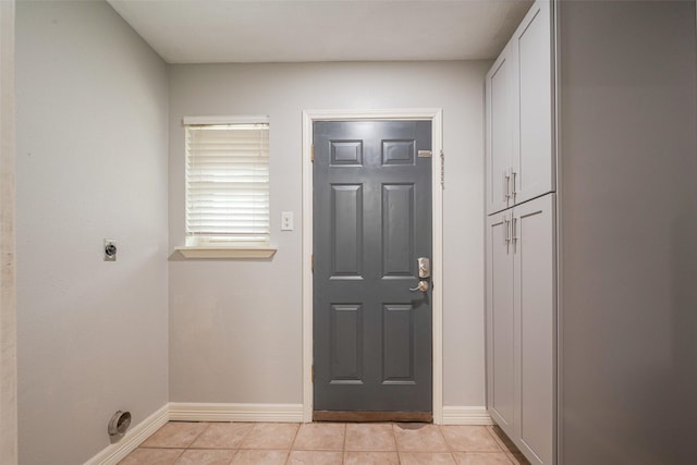 entryway with light tile patterned floors and baseboards