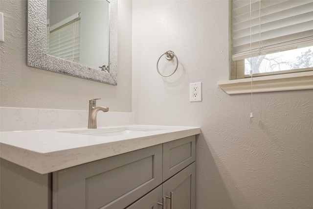 bathroom featuring a textured wall and vanity