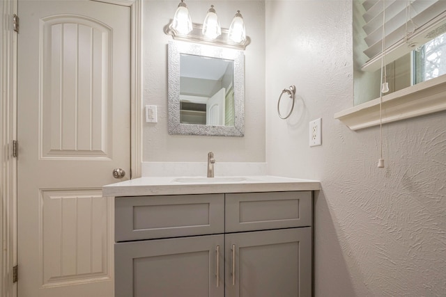 bathroom featuring a textured wall and vanity