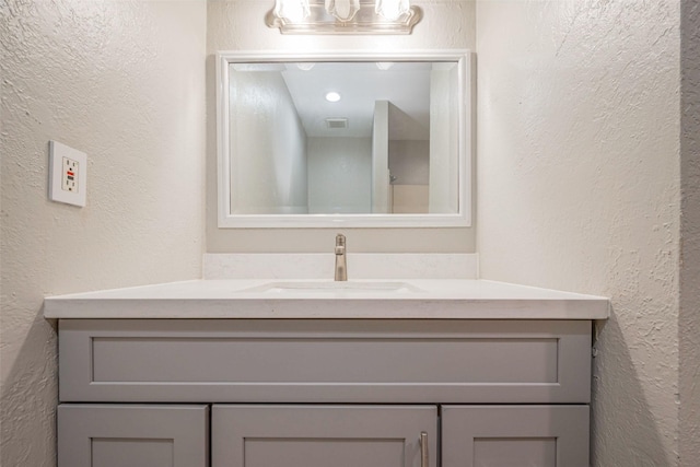 bathroom featuring vanity and a textured wall