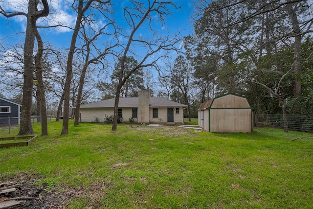 view of yard with an outdoor structure, a storage shed, and fence