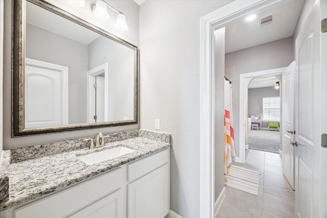 bathroom with visible vents, baseboards, curtained shower, tile patterned flooring, and vanity