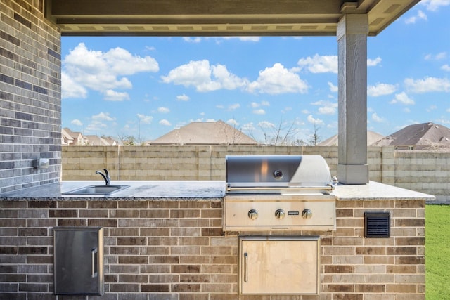 view of patio featuring exterior kitchen, fence, and area for grilling