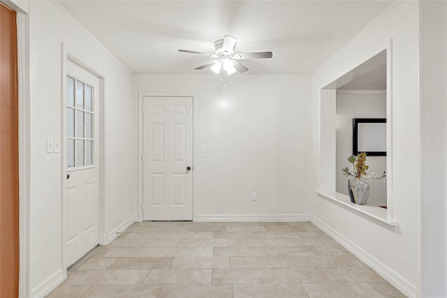 empty room with ceiling fan and baseboards