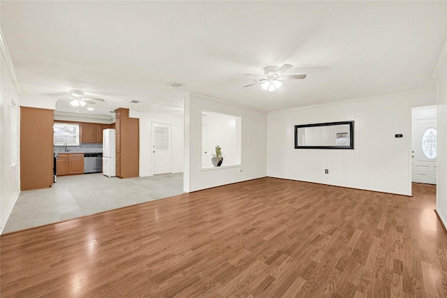 unfurnished living room featuring ornamental molding, light wood-style floors, ceiling fan, and a sink