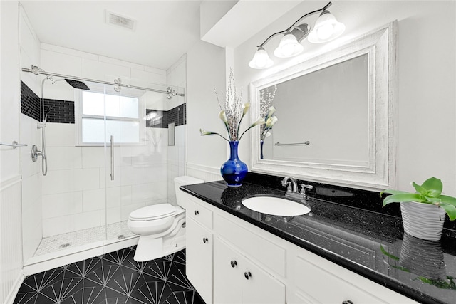 bathroom with visible vents, vanity, toilet, and a shower stall