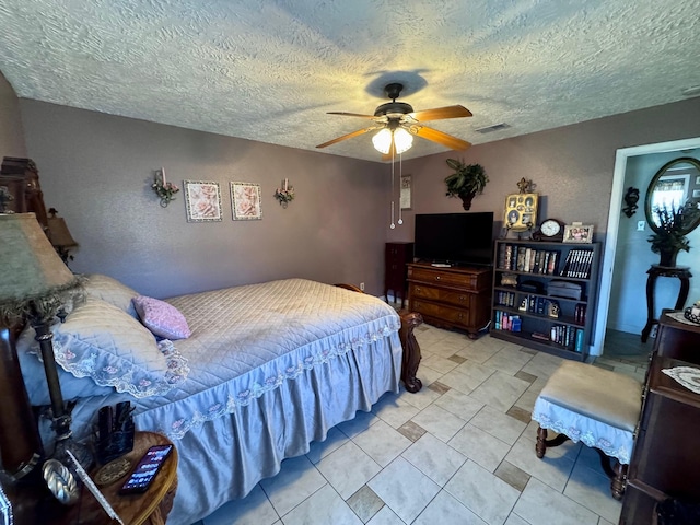 bedroom with ceiling fan, visible vents, and a textured ceiling