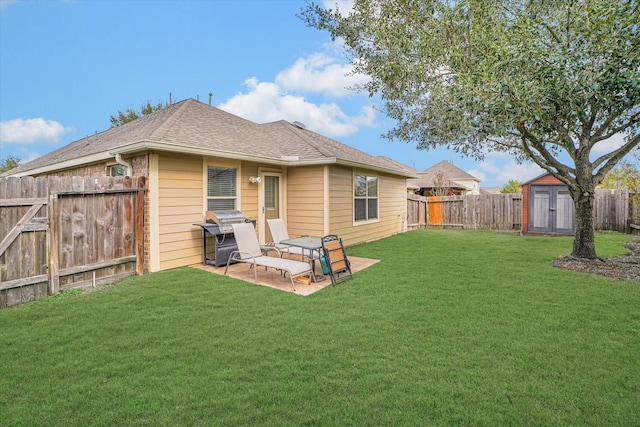 rear view of house with an outbuilding, a lawn, a storage shed, a patio area, and a fenced backyard