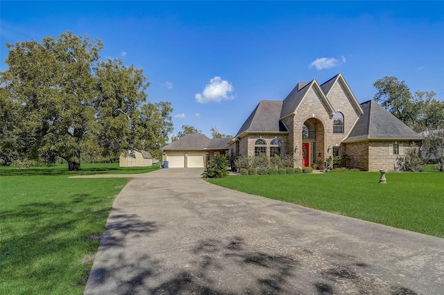 french provincial home with brick siding and a front yard