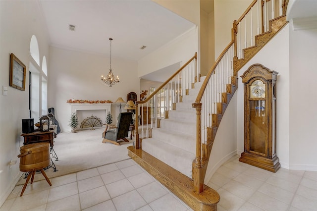 foyer entrance featuring light tile patterned floors, visible vents, ornamental molding, baseboards, and stairs