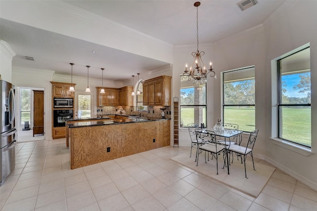 kitchen featuring brown cabinets, built in microwave, oven, and visible vents