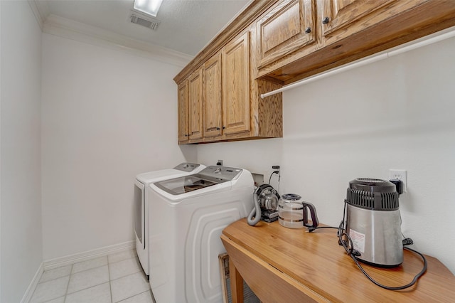 laundry room featuring cabinet space, light tile patterned floors, visible vents, washer and clothes dryer, and crown molding