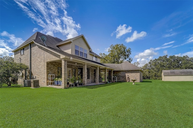 back of property with brick siding, a lawn, and cooling unit