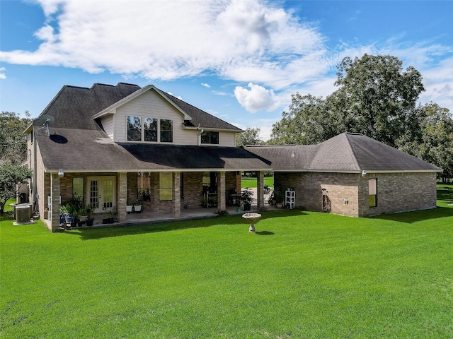 back of property featuring a patio, brick siding, a lawn, and french doors