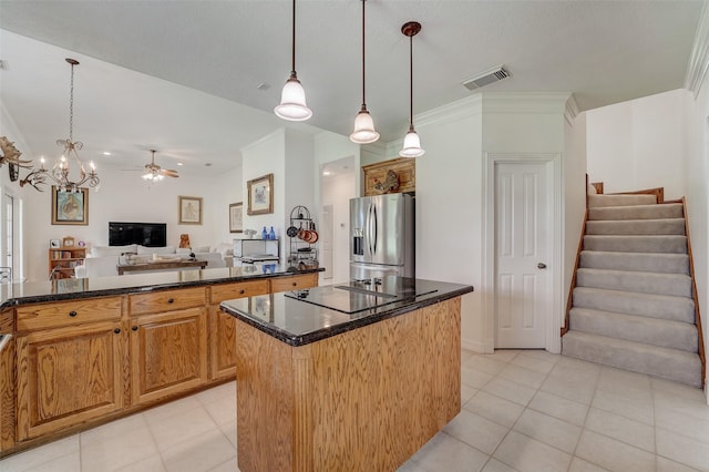 kitchen featuring black electric stovetop, visible vents, open floor plan, a center island, and stainless steel fridge