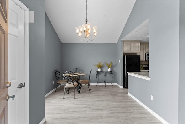 dining room with light wood-style floors, baseboards, a chandelier, and vaulted ceiling