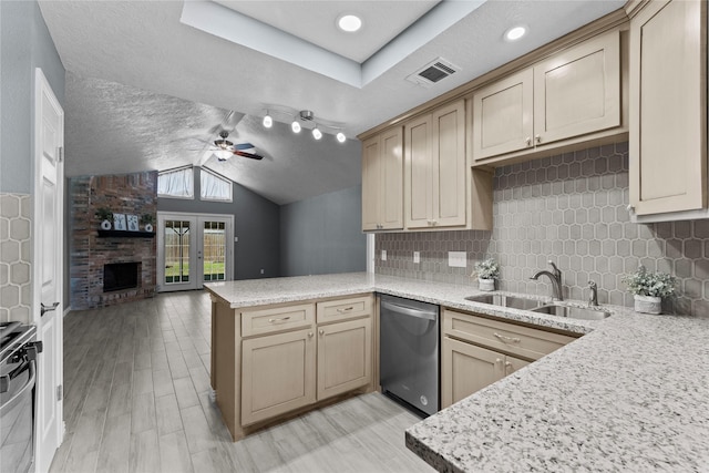 kitchen featuring visible vents, range, dishwasher, a peninsula, and a sink