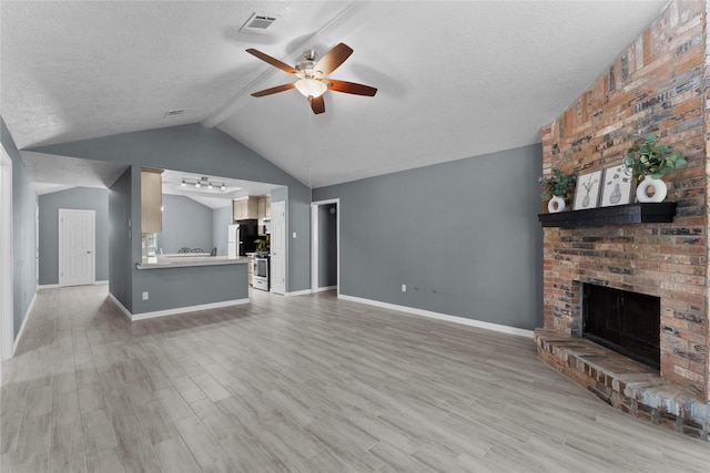 unfurnished living room featuring lofted ceiling with beams, light wood-style floors, a textured ceiling, and a ceiling fan