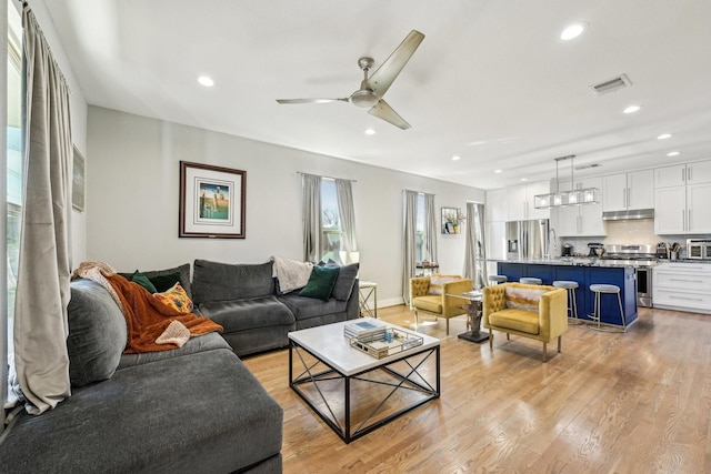 living area with light wood-type flooring, visible vents, a ceiling fan, and recessed lighting