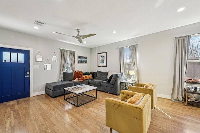 living room featuring light wood-style floors, recessed lighting, visible vents, and baseboards