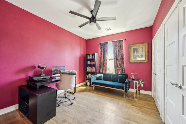 office area featuring baseboards, a ceiling fan, wood finished floors, and visible vents