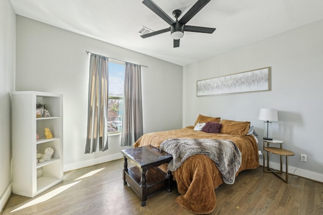 bedroom with ceiling fan, wood finished floors, visible vents, and baseboards