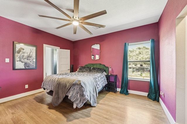 bedroom featuring ceiling fan, baseboards, and wood finished floors