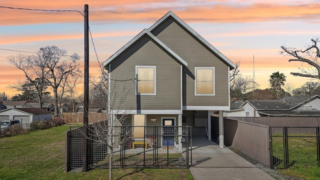 view of front of home featuring a fenced front yard, a front yard, a gate, and concrete driveway