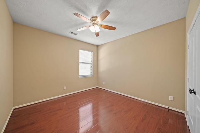 empty room with baseboards, a textured ceiling, ceiling fan, and wood finished floors