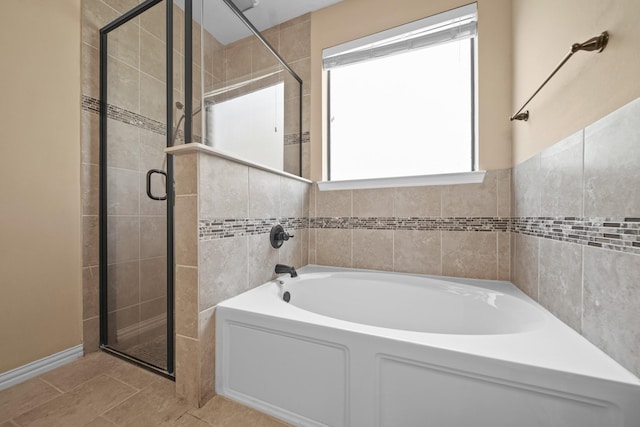 bathroom featuring tile patterned flooring, a shower stall, and a bath