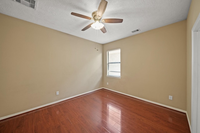 empty room featuring visible vents, a textured ceiling, wood finished floors, and a ceiling fan