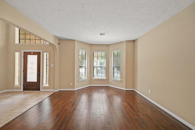 entryway featuring wood finished floors, baseboards, and a textured ceiling