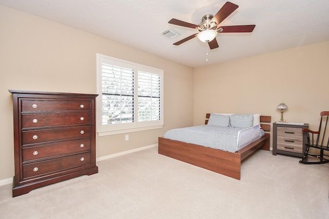 bedroom featuring visible vents, baseboards, light colored carpet, and ceiling fan