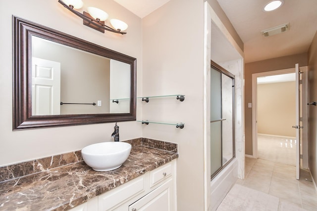 full bathroom with vanity, baseboards, visible vents, enclosed tub / shower combo, and tile patterned floors