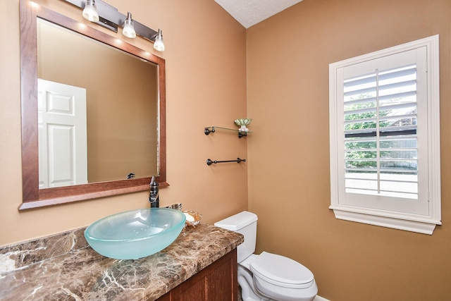 half bathroom with toilet and vanity