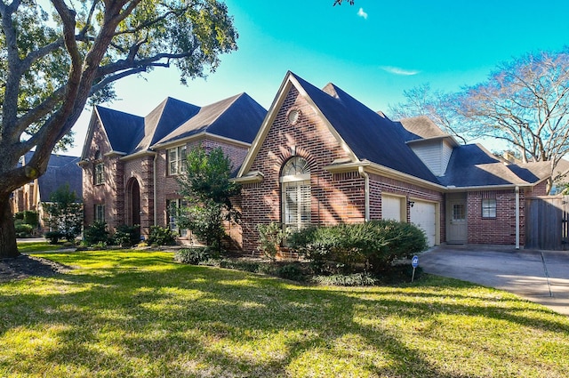 view of front of home with a garage, driveway, brick siding, and a front lawn