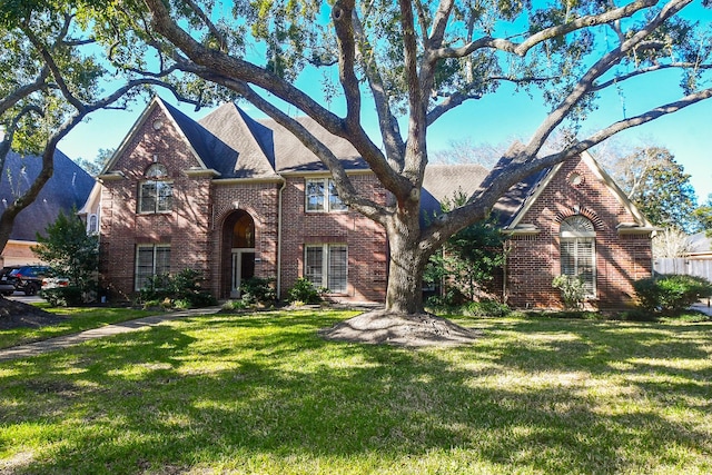 view of front of home with brick siding and a front lawn